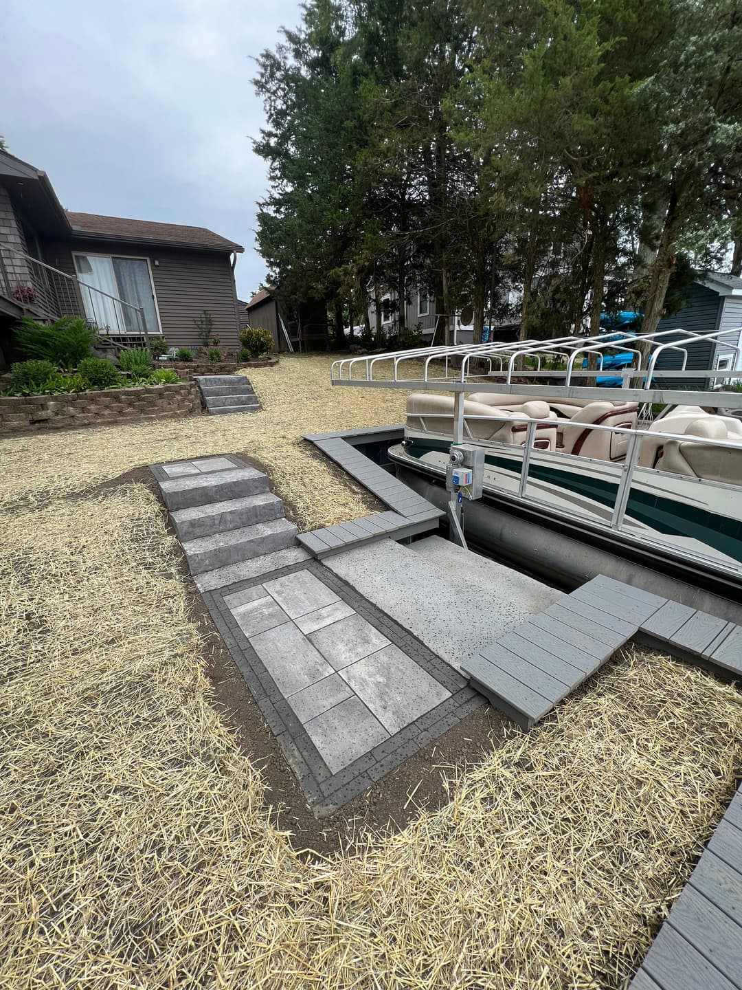 Stylish boat dock with stone pathway and lush greenery by the lake. Ideal summer getaway.
